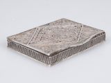 une boîte ancienne en argent sur fond blanc, ornée d'un motif