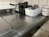 plan de travail en acier inoxydable dans une cuisine professionnelle, avec des casseroles et des poêles