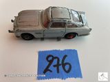 une petite voiture sur laquelle figure un numéro, à côté d'un bout de papier