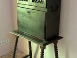 a small green cabinet on a wooden table