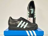 men ' s adidas sneakers in black and white on a blue box