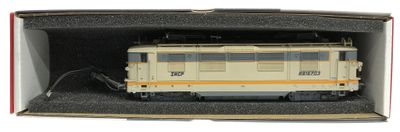 un petit train dans une boîte posée sur une surface blanche