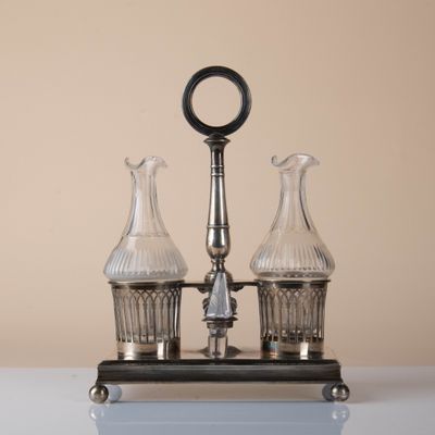 two glass vases sitting on top of a metal stand
