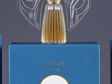 two bottles of perfume sitting on top of a table next to each other