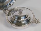 a silver plate with a lid and a bowl on the table