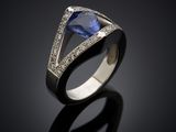 a blue sapphire and diamond ring on a black surface