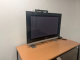 une télévision à écran plat posée sur un bureau en bois