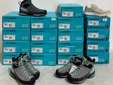 Plusieurs paires de chaussures sont empilées sur une pile de cartons