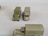 toy army vehicles are lined up in a row on a white surface