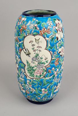 un vase bleu orné d'un motif représentant des oiseaux et des fleurs