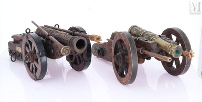 deux vieilles roues de canon posées l'une à côté de l'autre sur une surface blanche
