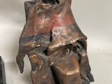 a bronze statue of a man sitting on a chair