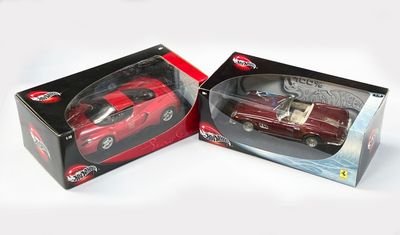une petite voiture rouge dans une boîte sur une surface blanche