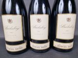 three bottles of wine are lined up on a table
