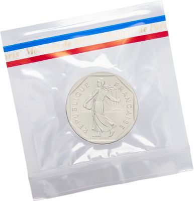 a silver coin in a plastic bag with a red, white and blue stripe