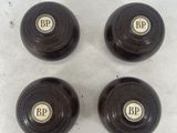 three black wooden knobs with brass numbers on them on a white surface
