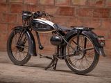 a black motorcycle parked in front of a brick wall