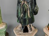 three ceramic figurines of a man with a hat and a robe