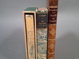trois livres sont empilés sur une surface grise