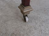 a close up of a clock on wheels on the ground