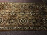 rug on the floor in a room with a cat laying on top of it