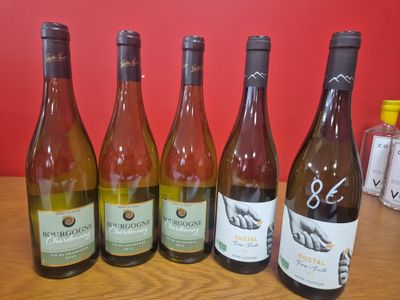 six bouteilles de vin sont alignées sur une table en bois