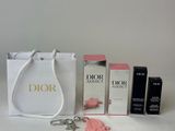 a white bag with a keychain, lipstick, and other items sitting on a table