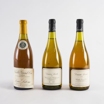 trois bouteilles de vin posées les unes à côté des autres sur une surface blanche