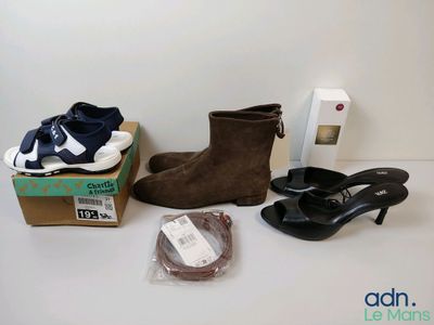 Plusieurs paires de chaussures sont posées sur une table, à côté d'une boîte de chaussures.