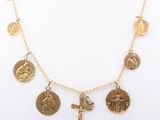 a close up of a gold necklace with a cross on it
