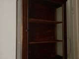 a wooden cabinet with a glass door in a room