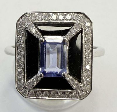 gros plan d'une bague avec une pierre bleue entourée de diamants