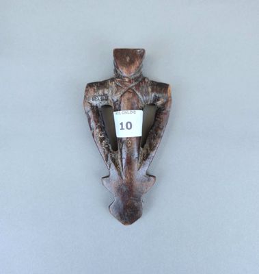 une photo d'une sculpture en bois représentant un homme sur laquelle figure le chiffre 10