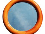 un miroir rond en bois dans lequel se reflète le ciel