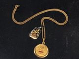 a close up of a gold locke with a chain on a black surface
