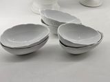 several white bowls and bowls are sitting on a white table