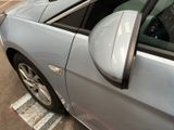a silver car parked in a parking lot with its door open