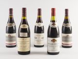 several bottles of wine are lined up on a white surface