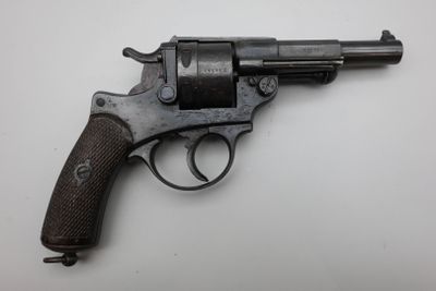 gros plan d'un pistolet sur une table à fond blanc