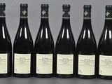 six bottles of wine are lined up in a row on a table