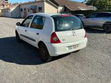une petite voiture blanche garée sur le bord de la route