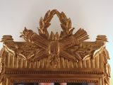 a mirror that has a gold frame with a picture in it