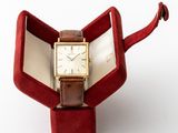 a watch sitting in a red box on a white surface