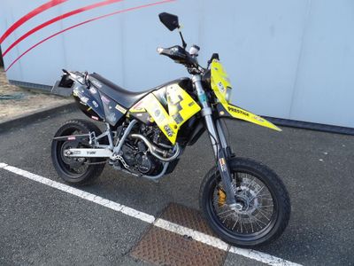 une moto tout-terrain jaune et noire garée sur un parking