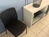 a black chair and a white cabinet in a room