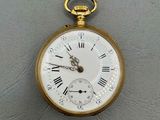 une montre de poche en or avec des chiffres romains sur le cadran