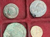 several ancient roman coins are in a red box on a table