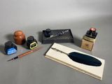 un stylo, un encrier et un flacon d'encre posés sur une table