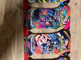 three pokemon trading cards on a wooden table with one of them in the foreground