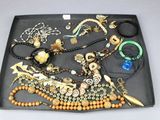 un plateau noir sur lequel sont disposés de nombreux bijoux